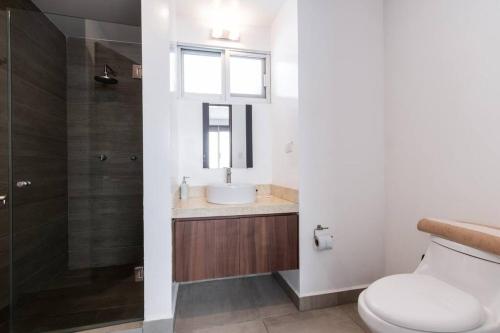a bathroom with a toilet and a sink and a shower at 2min plaza Galerías y 5 min de playa by PartnerHost in Mazatlán