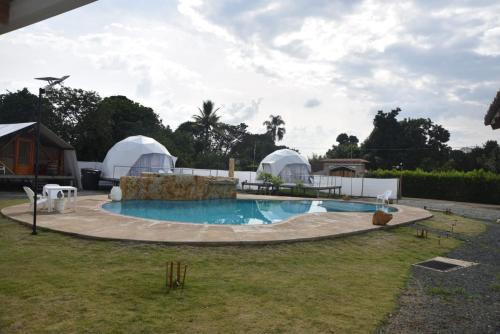 a swimming pool with domes in a yard at Eco Cabañas Montana - Glamping 2 