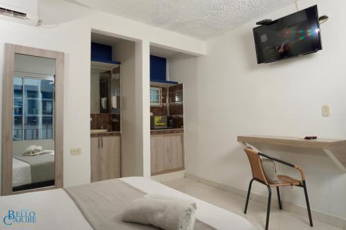 um quarto com uma cama e uma televisão na parede em Hotel Bello Caribe em Santa Marta