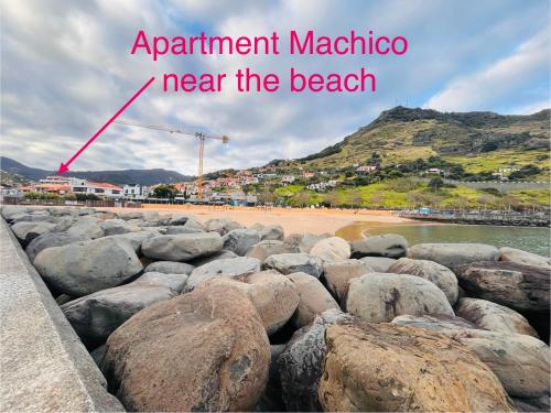 a beach with large rocks and a mountain at Apartment Machico near the beach in Machico