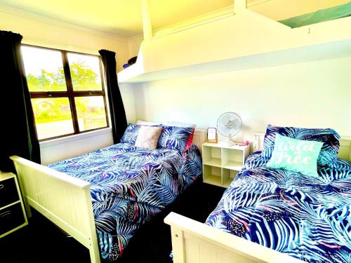 Habitación con 2 camas y ventana en Lake life with a hot tub, en Mangakino