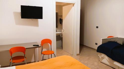 a bedroom with orange chairs and a desk and a bed at Sweet Home Tempo Libero in San Severo