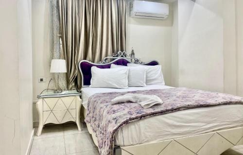 a bedroom with a bed with a purple and white bedspread at Alexandria Luxury Apartments Sporting Direct Sea View in Alexandria
