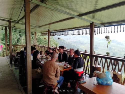 un gruppo di persone seduti ai tavoli in un ristorante di Cứ A Lồng Homestay a Bản Hon