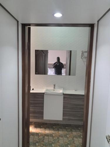 un homme prenant une photo d'un miroir de salle de bains dans l'établissement Nkolokosa BnB, à Blantyre