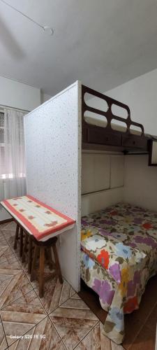 a bedroom with a bunk bed and a bench at Apto no Embaré pé na areia in Santos