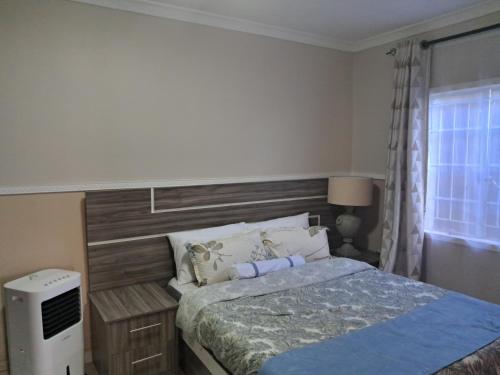 1 dormitorio con 1 cama grande y cabecero de madera en Nkolokosa BnB en Blantyre