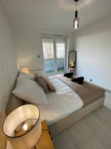 a bedroom with a large white bed and a window at ST TOWER Apartament in Rzeszów