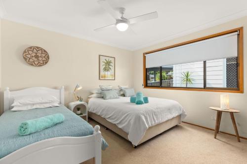 a bedroom with two beds and a large window at Aqua by Experience Jervis Bay in Sanctuary Point