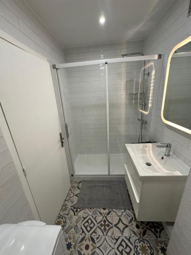 a white bathroom with a shower and a sink at Studio Villennes sur seine cosy Paris Versailles in Villennes-sur-Seine