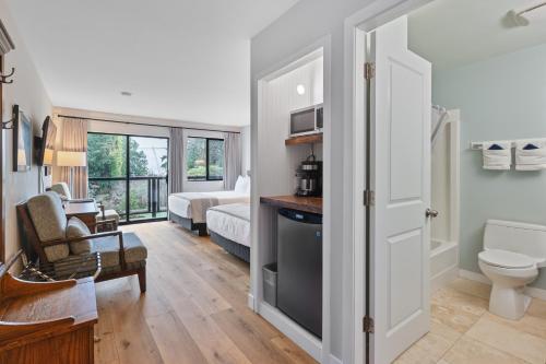 a living room with a toilet and a bedroom at Tofino Motel Harborview in Tofino