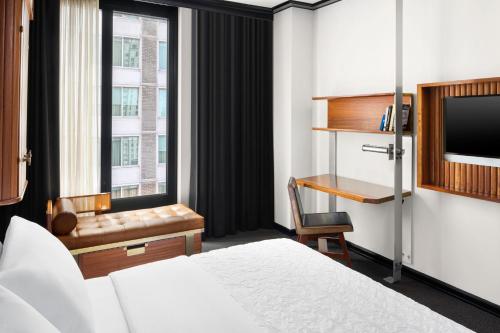 a hotel room with a bed and a desk and a window at Le Meridien New York, Central Park by Marriott in New York