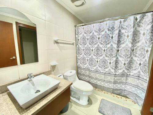 a bathroom with a sink and a shower curtain at Departamento con Piscina en el último piso del edificio in Guayaquil