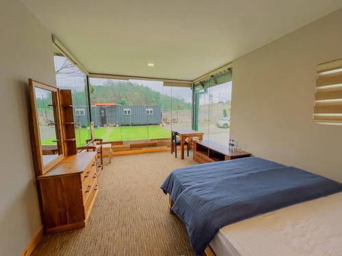 1 dormitorio con cama, escritorio y ventana en Mount Star Villa, en Nuwara Eliya