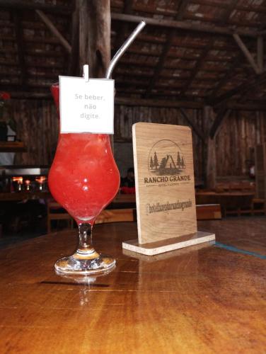 a drink in a glass sitting on top of a table at Hotel Fazenda Rancho Grande in Linha Blinda