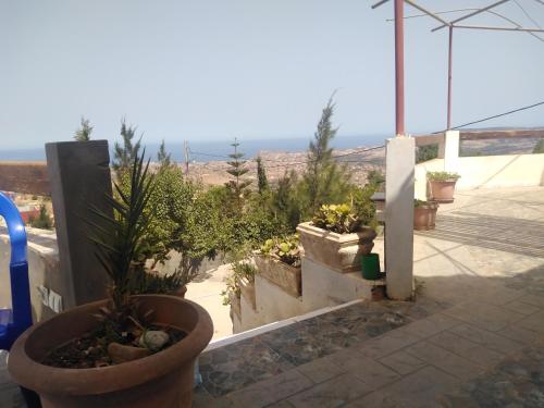 a garden with potted plants and a view of the desert at Villa de campagne dans les hauteurs, vue panoramique sur mer in Ghazaouet