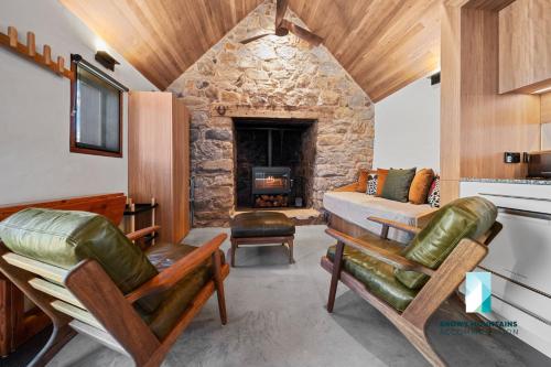 Zimmer mit einem Bett und einem Steinkamin in der Unterkunft The Stone Cottage at Wollondibby - Heritage Listed l Renovated l Fire Place in Crackenback