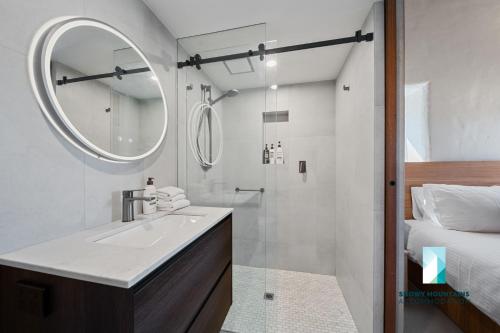 ein Badezimmer mit Waschbecken und Spiegel und einem Bett in der Unterkunft The Stone Cottage at Wollondibby - Heritage Listed l Renovated l Fire Place in Crackenback