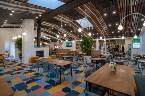 a restaurant with wooden tables and chairs and a lobby at Peninsula Hotel Motel in Adelaide