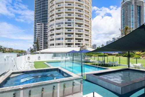 a swimming pool with a large building in the background at Focus Apartments With Ocean Views in Gold Coast