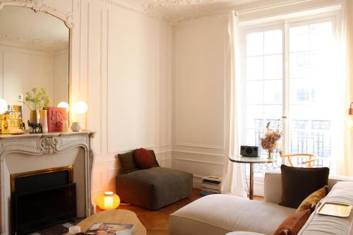 een woonkamer met een bank en een open haard bij Spacious haussmann apartment in Parijs
