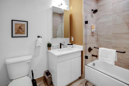 a bathroom with a toilet and a sink and a shower at Flamboyant 1BR Near EWR w/ Gym in Newark