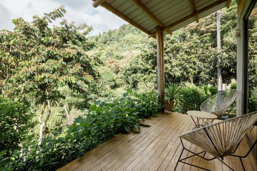 een houten terras met stoelen en uitzicht op een berg bij El Fenix Coffee in Calarcá