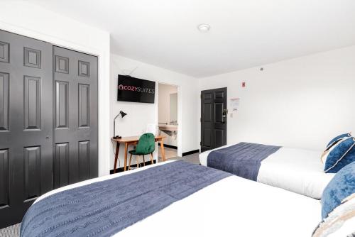 a bedroom with two beds and a desk with a table at CozySuites CWE Double Queen Suite in Saint Louis