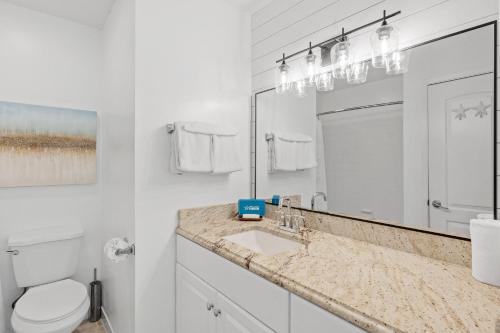 a bathroom with a sink and a toilet and a mirror at Beachwalk Villa 5117 in Destin