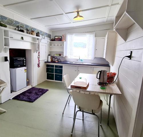 a small kitchen with a table and chairs in it at Truffle Honey Cottage in Warkworth