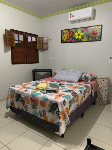 a bedroom with a bed with a comforter on it at Casa no francês! in Marechal Deodoro