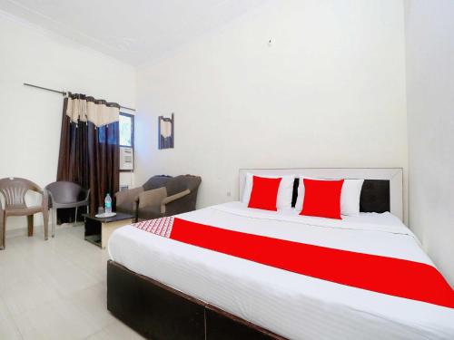 een slaapkamer met een groot bed met rode kussens bij OYO Flagship Welcome Lounge in Shāhpur