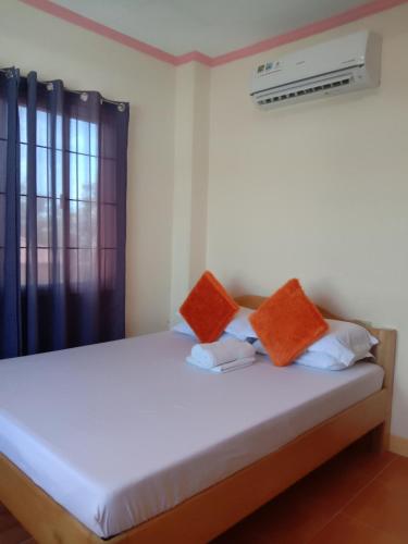 a bedroom with a bed with orange and white pillows at Friz Love Room Rental in San Juan