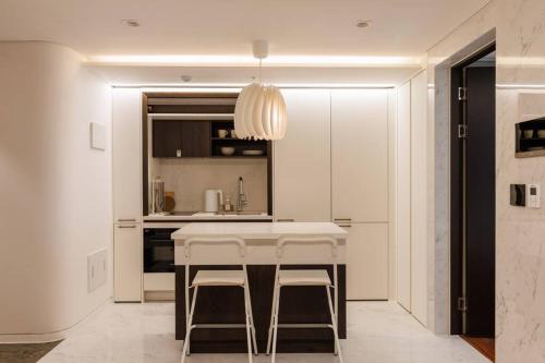 a kitchen with a white table and two stools at Wecostay Gangnam in Seoul