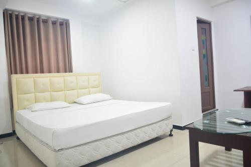 Schlafzimmer mit einem Bett und einem Glastisch in der Unterkunft Saasha City Hotel in Colombo