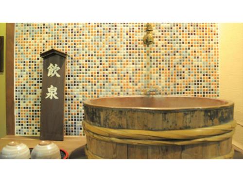 baño con bañera de madera y pared de mosaico en Yoro Onsen Honkan - Vacation STAY 09626v en Onomichi