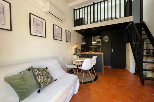 a living room with a couch and a table at Charming Mazet ideal for families swimming pool tennis in Maussane-les-Alpilles