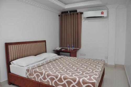 a bedroom with a bed and a table and a window at Saasha City Hotel in Colombo