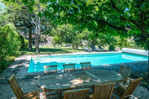 - une table et des chaises à côté de la piscine dans l'établissement Villa Les Saffres in Malaucene, à Malaucène