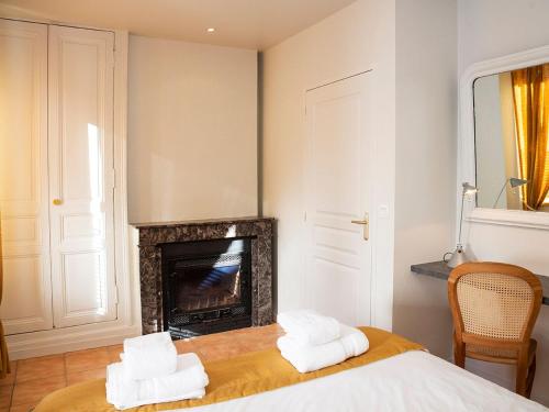 sypialnia z kominkiem i ręcznikami na łóżku w obiekcie Gîte Déols, 6 pièces, 14 personnes - FR-1-591-167 w mieście Déols