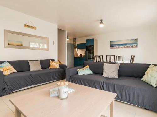 un salon avec deux canapés et une table dans l'établissement Maison récente à 200 m de la plage avec jardin clos, terrasse, vélos et wifi à Mesquer - FR-1-306-1265, à Mesquer