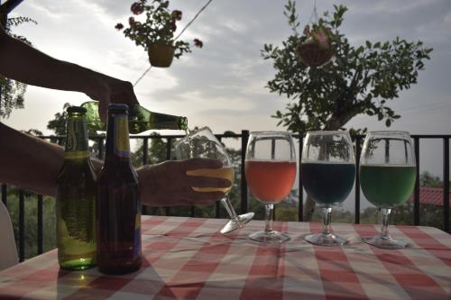 a person pouring wine into three wine glasses on a table at Mirador La Gloria in Misiones