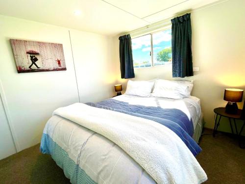 1 dormitorio con cama y ventana en Comfy and Cosy at the lake, en Mangakino