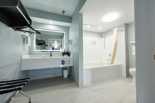 a bathroom with a sink and a tub and a toilet at Baymont by Wyndham Branson Thousand Hills in Branson