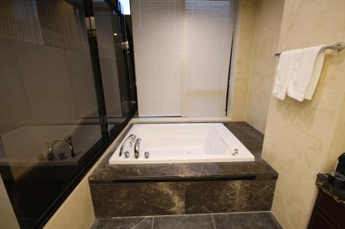 uma banheira na casa de banho com um chuveiro em JB Tourist Hotel em Daegu