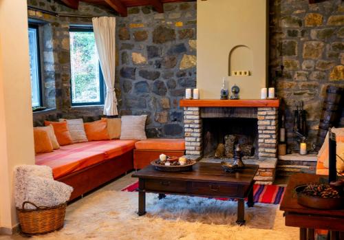a living room with a couch and a fireplace at Marianda's House - Mountain Views & Rustic Charm in Tíkhion