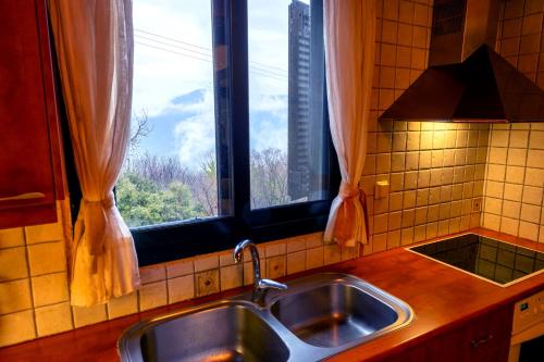 um lavatório de cozinha e uma janela com vista em Marianda's House - Mountain Views & Rustic Charm em Tíkhion