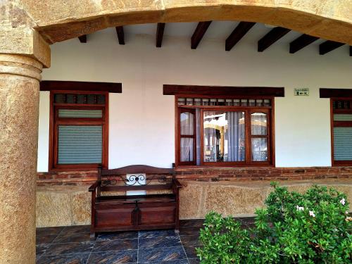 a building with two windows and a bench on a patio at Hotel Gran Sirius in Sáchica