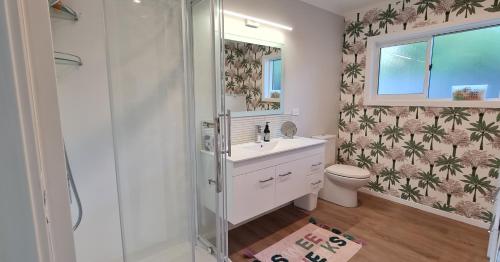 a bathroom with a shower and a sink and a toilet at Waikanae Beach Suite Retreat in Waikanae