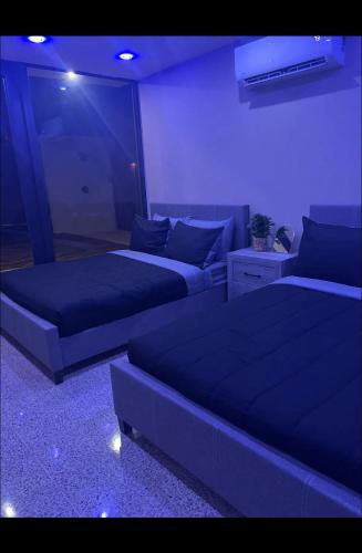 リオ・グランデにあるThe Olive House PRのベッド2台とソファが備わる客室です。